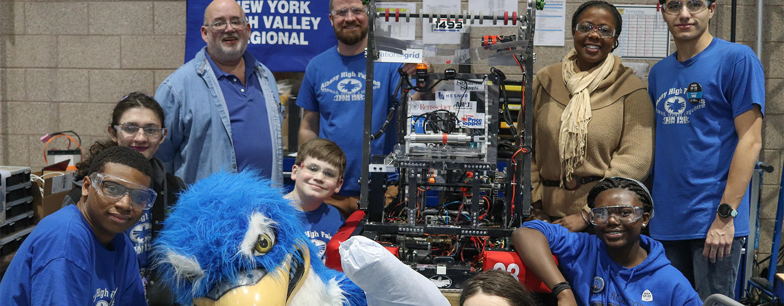 Robotics team posing for a group picture with the 33Ƶ High Falcon mascot.